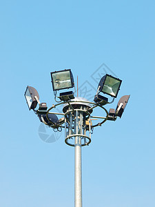 蓝色天空背景上的光极玻璃光灯交通体育场反光板聚光灯灯泡金属运动照明图片