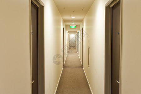 长走廊 有旅馆房间门和出境标志建筑学灯光墙壁指示牌酒店大厅天花板通道入口出口背景图片