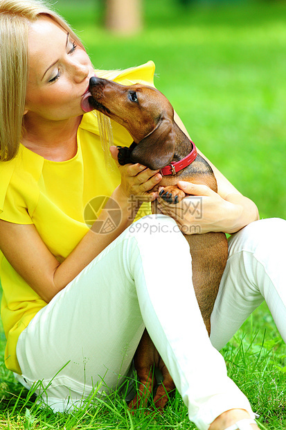 在她的怀里 有达赫松德的女子金发女性爪子犬类小狗宠物哺乳动物香肠拥抱女士图片