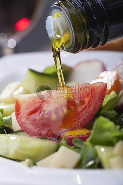 在沙拉上浇橄榄油黄瓜食物绿色立方体萝卜烹饪瓶子蔬菜敷料图片
