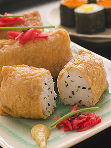 配有红采摘姜的寿司豆腐袋盘子香料食物豆腐美食食品草药图片