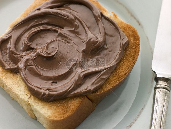 巧克力散漫的烤面包片切片鞋垫面包食物刀具黄油孩子们早餐用具烹饪小吃图片