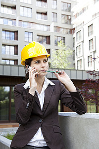 年轻女性有电话的建筑工程青年商务头盔工程师蓝色帽子呼唤承包商就业手机专家图片