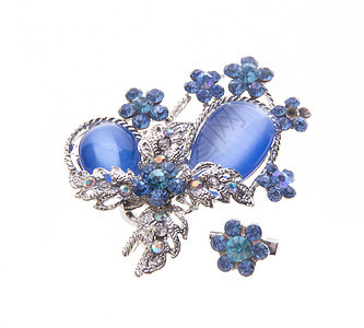 在背景上有着不同宝石的胸针金子火花水晶蓝色金属珠宝古董奢华叶子石头图片