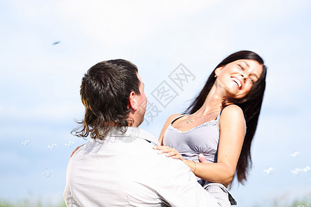 在天空中拥抱快乐友谊女性太阳乐趣妻子微笑成人男人情人图片