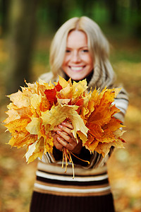 秋叶中的妇女脚尖毛衣眼睛女士女孩橙子团体成人叶子幸福女性图片