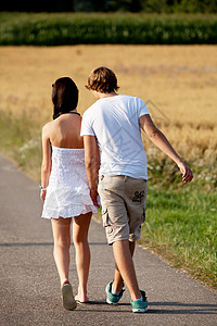 男女青年在夏季户外的一条公路上行走女孩公园夫妻自由享受女性人行道天空小路沥青图片