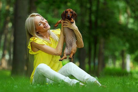 在她的怀里 有达赫松德的女子小狗拥抱金发香肠爪子眼睛犬类动物成人哺乳动物图片
