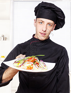 穿黑色制服的厨师提供沙拉图片