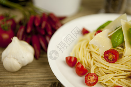 新鲜美味的意大利面 桌上有番茄和烤肉芳香香料烹饪蔬菜沙拉面条午餐美食营养盘子图片