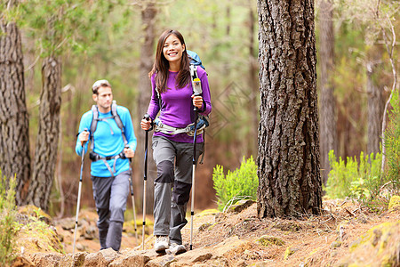 森林中的偷渡者微笑运动男人背包乐趣远足者树木女孩男性幸福图片
