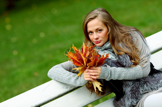 秋叶中的妇女脚尖成人公园眼睛叶子季节女性微笑团体金发女郎女孩图片