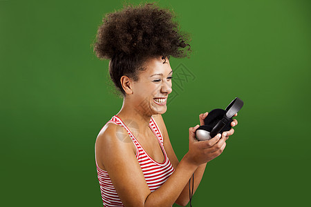 听音乐喜悦黑发耳机女性享受音乐绿色青少年手机微笑图片