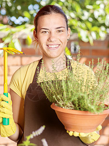 种植锅里的植物花朵栽培女士手套晴天女孩花园工作园艺围裙图片