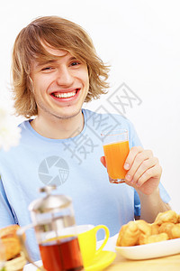 年轻人喝果汁男性健康快乐蓝色小吃早餐水果房间厨房饮食图片