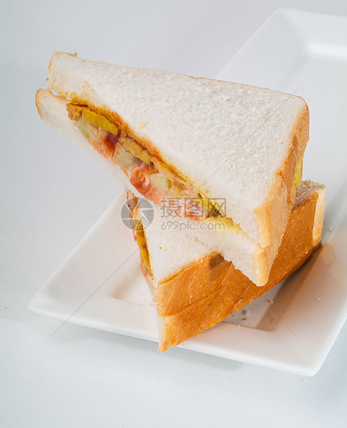 三明治 夹在背景上的三明治垃圾面包食物叶子小吃猪肉熟食家禽洋葱蔬菜图片