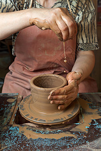 波特在陶瓷轮上制造了一个投手艺术血管拇指压力工作制品车轮黏土手工业专注图片