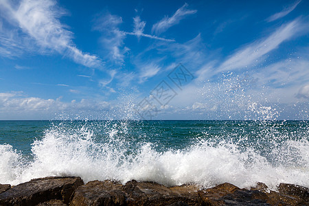 海浪在沙滩上破碎天气飞溅海岸力量碰撞天空石头海滩阳光海岸线图片
