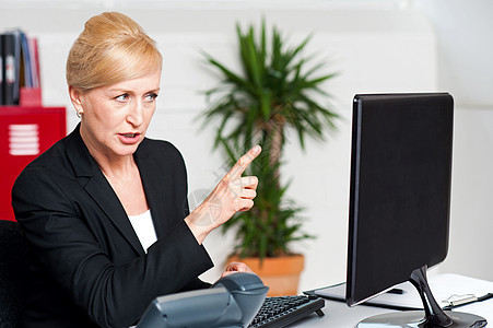 愤怒的女人在计算机引导的屏幕上表示图片