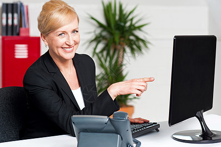 商业妇女指向计算机屏幕商务办公桌管理人员电话办公室职业女士电脑老板女性图片