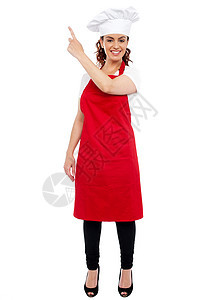 女性厨师指向远方的全长肖像围裙餐厅工作帽子厨房面包师商业餐饮面包快乐图片