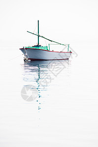 孤单的渔船在非常平静的海面上图片