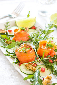 配有石榴和胡桃沙拉的熏鲑鱼橙子绿色食物营养健康树叶水果美食红色火箭图片
