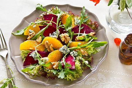 Beetroot 含蓝奶酪和火箭沙拉的紫菜根橙子美食美味树叶红色核桃黄色蔬菜矿物食物图片