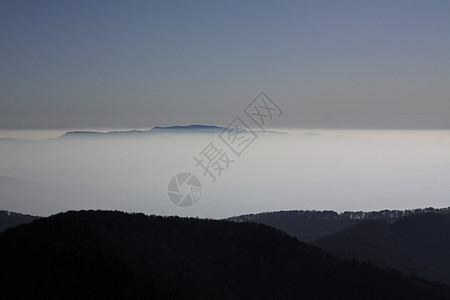 云层之上薄雾丘陵山脉天空全景图片