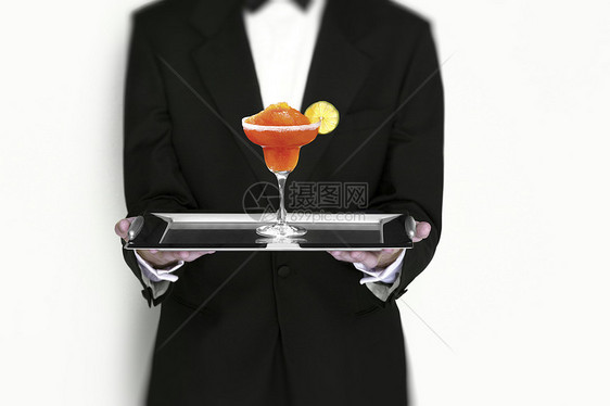 曼哈顿鸡尾酒由银托盘服务员服务图片