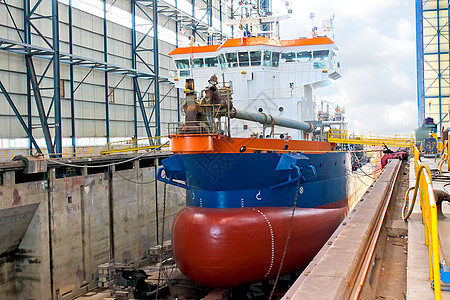 船舶停靠在船坞的干码头工人港口修理工作商业船体甲板起重机维修货物图片