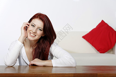 年轻女性在家放松头发休息女士快乐白色客厅休息室微笑红色图片