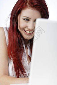 妇女在家里使用膝上型电脑红色女性头发快乐女士微笑笔记本图片