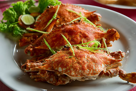 三个大红螃蟹加沙拉和石灰旅游贝类午餐美味硬壳餐厅食物油炸盘子柠檬图片