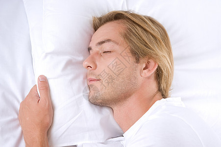 年轻男子在床上睡觉男人说谎棕榈毯子衣服卧室金发亚麻男性用品图片