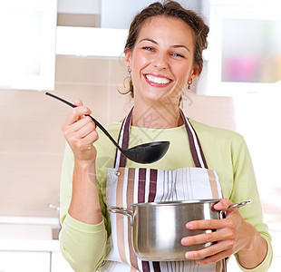 年轻妇女烹饪健康食品牙齿微笑生活金属蔬菜食谱沸腾幸福妻子房子图片