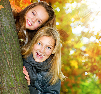 美丽的年轻女孩在秋天公园玩得开心假期女学生学生公园乐趣树木家庭微笑女朋友天空图片