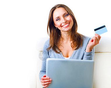 使用信用卡和电脑在网上购物的笑女 Inte互联网信用电子卡片女性笔记本沙发零售女士网络图片