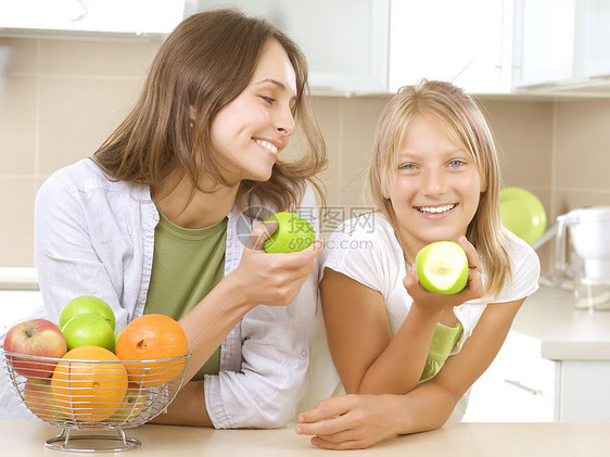 幸福的家庭母亲和女儿一起吃健康的食物 饮食营养水果牙齿果汁黑发女性女士乐趣厨房享受图片