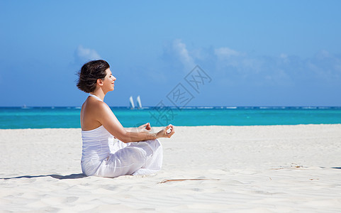 沙滩上的默思活力瑜伽保健冥想女性天空自由女孩享受蓝色图片