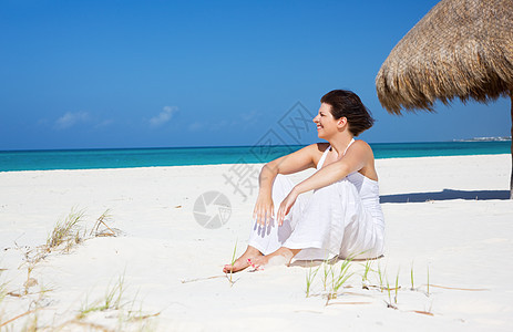 在海滩上快乐的女人自由女性天堂阳光享受天空旅行微笑娱乐中年图片