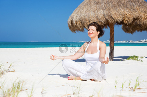 沙滩上的默思女孩微笑海滩瑜伽享受保健蓝色福利锻炼冥想图片