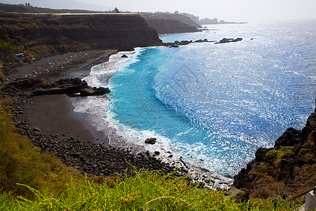 Bullullo海滩黑棕色沙和水异国海洋支撑泡沫石头海景火山天线情调蓝色图片