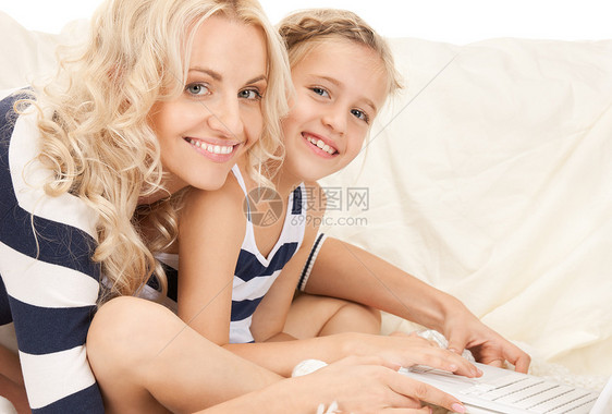 使用笔记本电脑的幸福母亲和孩子互联网购物女儿童年教育微笑女孩快乐妈妈女士图片