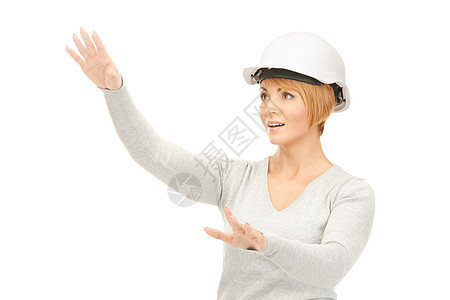 戴头盔的女女承包商与想象中的东西一起工作女性微笑企业家手掌建筑开发商女士手势中年工程师图片
