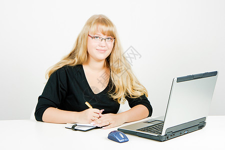 拿着笔记本电脑的金发女孩杯子女士桌子快乐作家学习员工职业商业眼睛图片