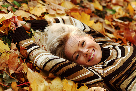 秋叶中的妇女脚尖乐趣眼睛成人季节女士叶子女孩幸福头发公园图片