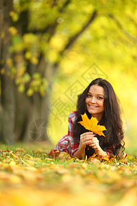 秋叶中的妇女脚尖公园毛衣微笑成人女孩叶子头发团体女士乐趣图片