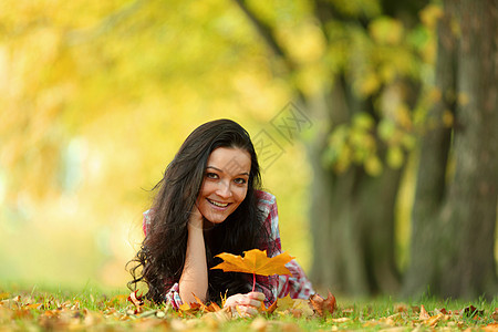 秋叶中的妇女脚尖眼睛橙子微笑团体金发女郎公园女孩乐趣女士季节图片