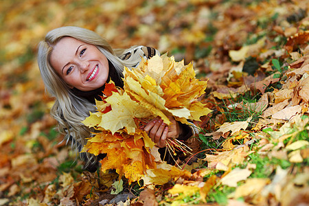 秋叶中的妇女脚尖微笑乐趣感恩幸福毛衣女孩公园团体叶子季节图片